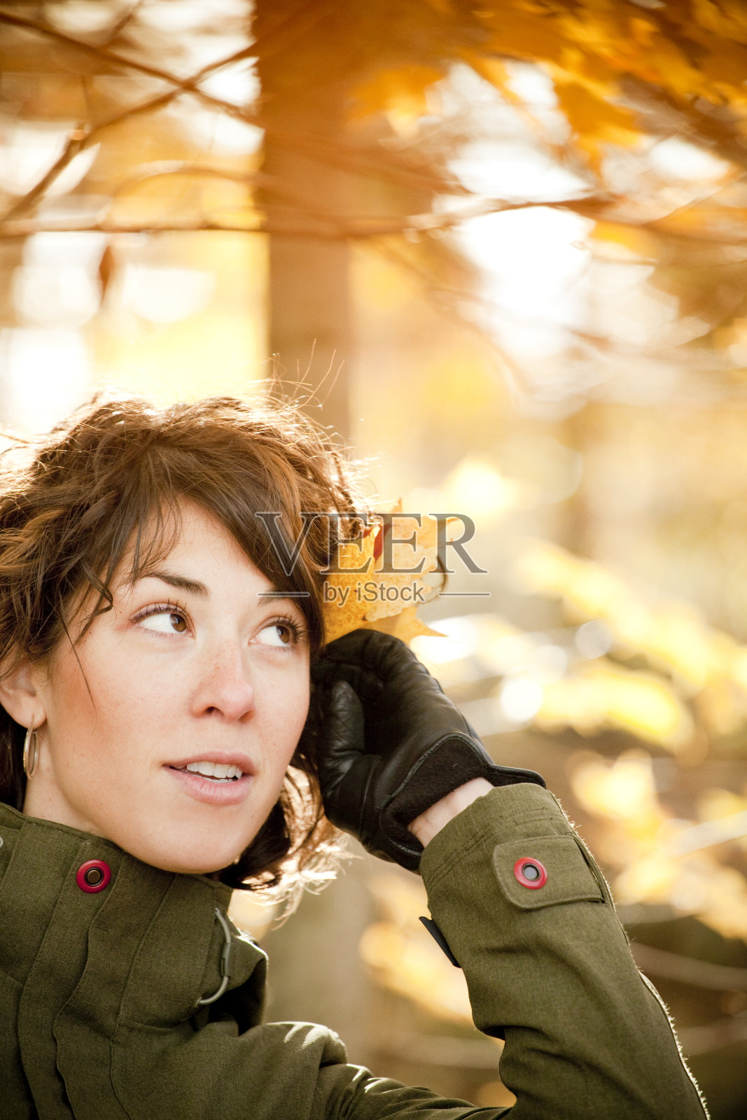 一个顽皮的年轻女子，头发上插着一片树叶照片摄影图片