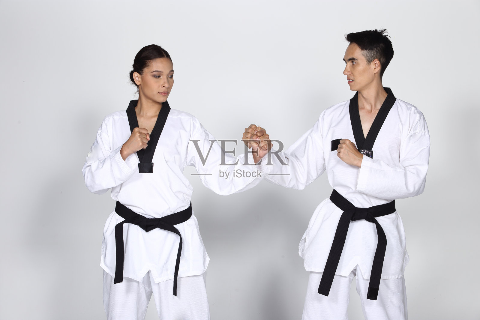 两个男人和女人大师黑带跆拳道老师展示搏击课踢和拳照片摄影图片