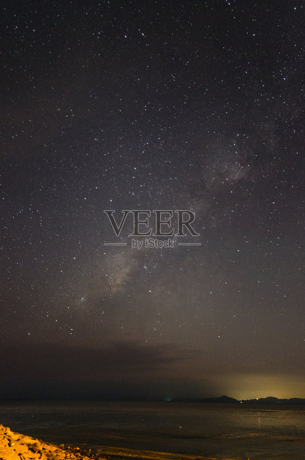 天空上的银河与黄色光污染的岩石形成照片摄影图片