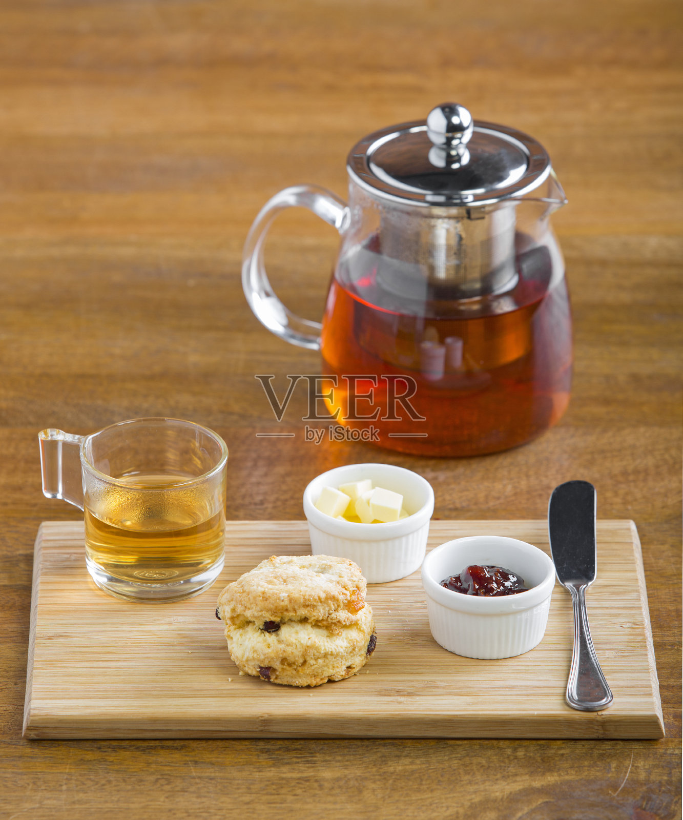 早餐桌上有茶，茶壶，果酱，面包和蜂蜜照片摄影图片