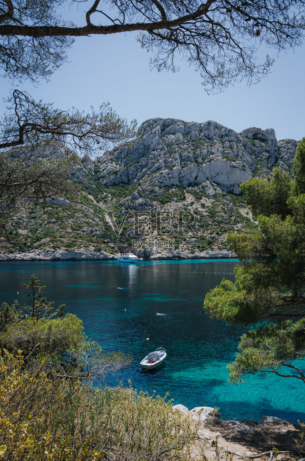 一艘白色游艇停泊在马赛附近的卡纳克斯国家公园港口。垂直旅游明信片。照片摄影图片