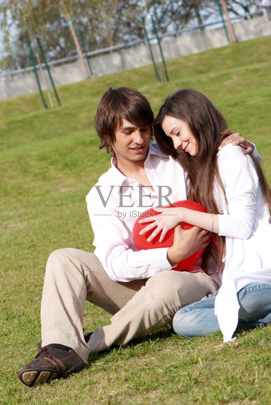 一对年轻夫妇在公园的空地上照片摄影图片