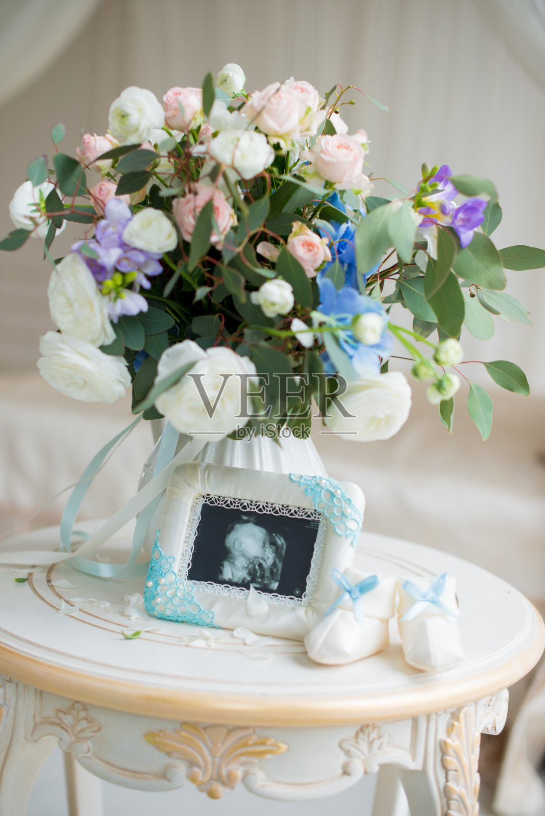 儿童鞋和超声波胎儿与一束美丽的鲜花照片摄影图片