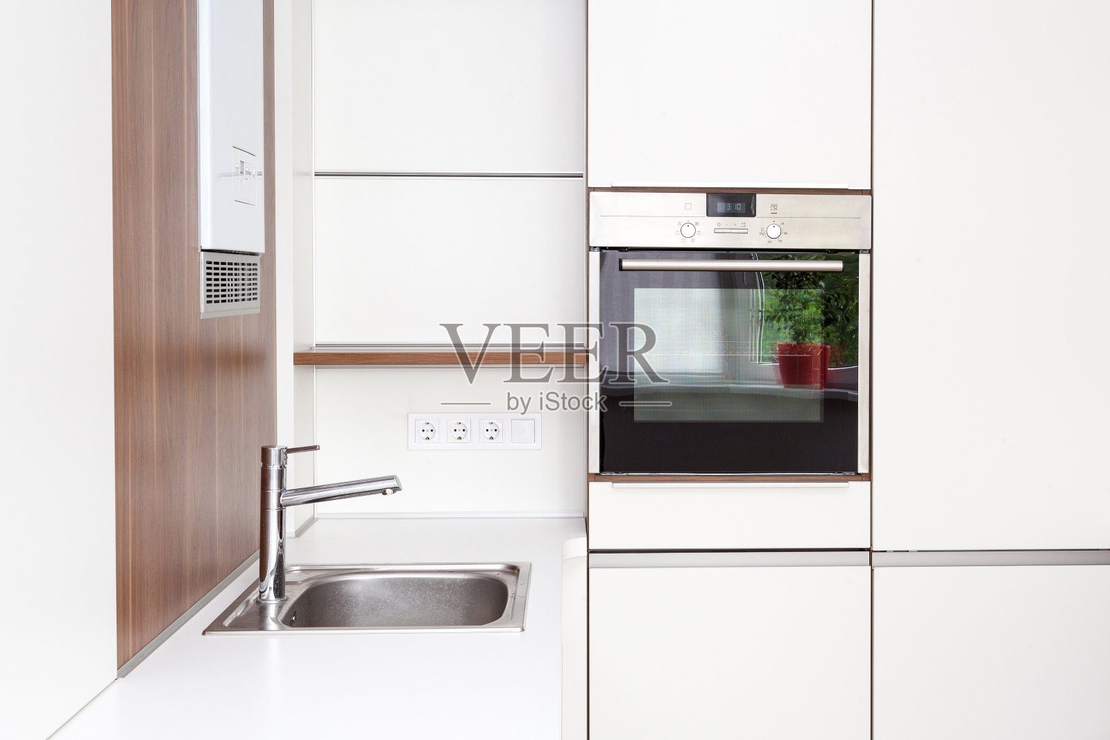 现代化的白色厨房，内置烤箱和水龙头照片摄影图片