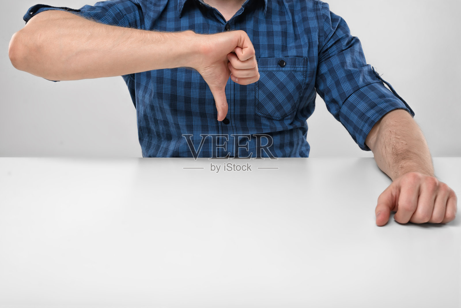 剪裁过的男性的手显示拇指向下的图像。手势照片摄影图片