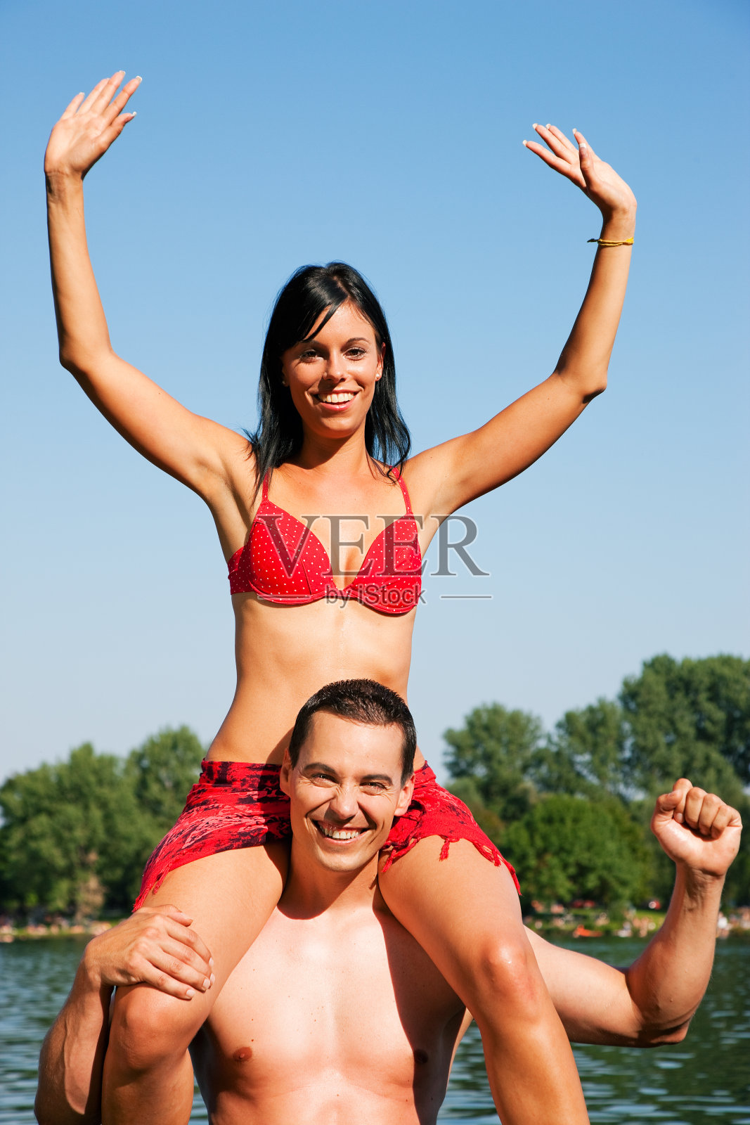 夏天的比基尼女孩坐在男人的肩膀上照片摄影图片