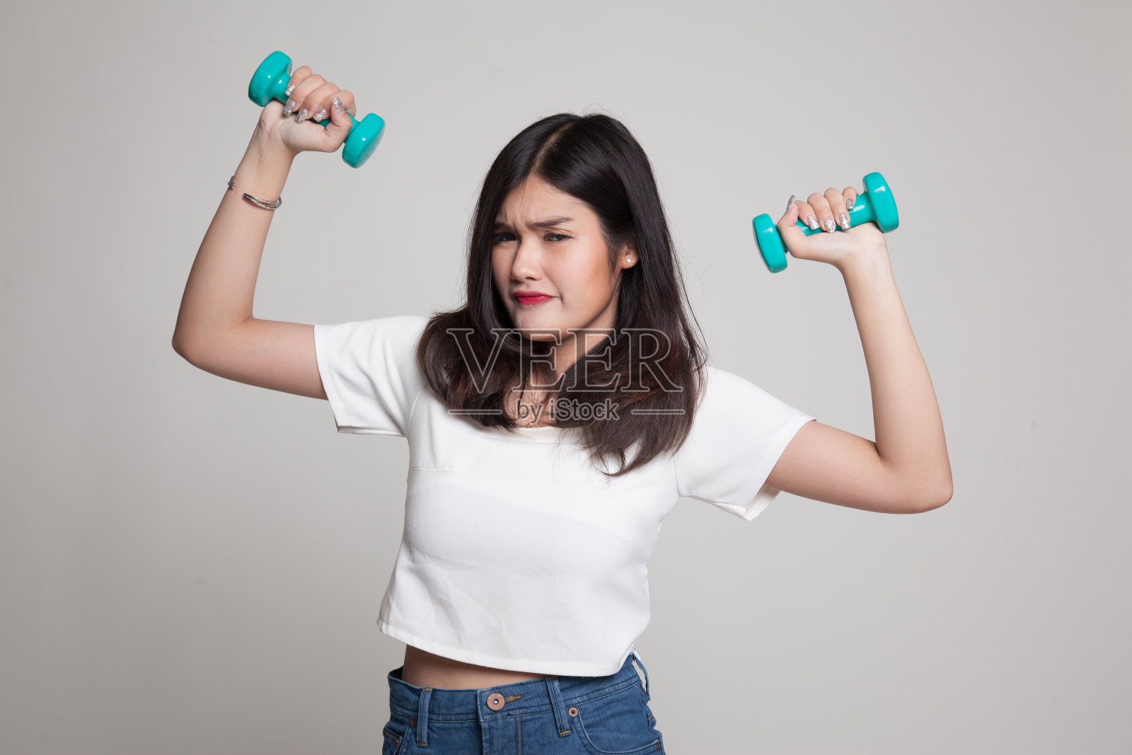 疲惫的亚洲女人拿着哑铃。照片摄影图片