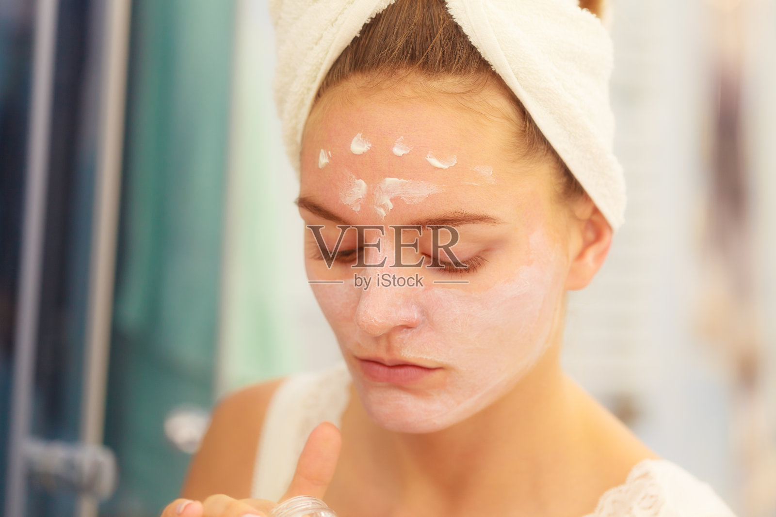 在浴室里给脸上敷面膜的女人照片摄影图片
