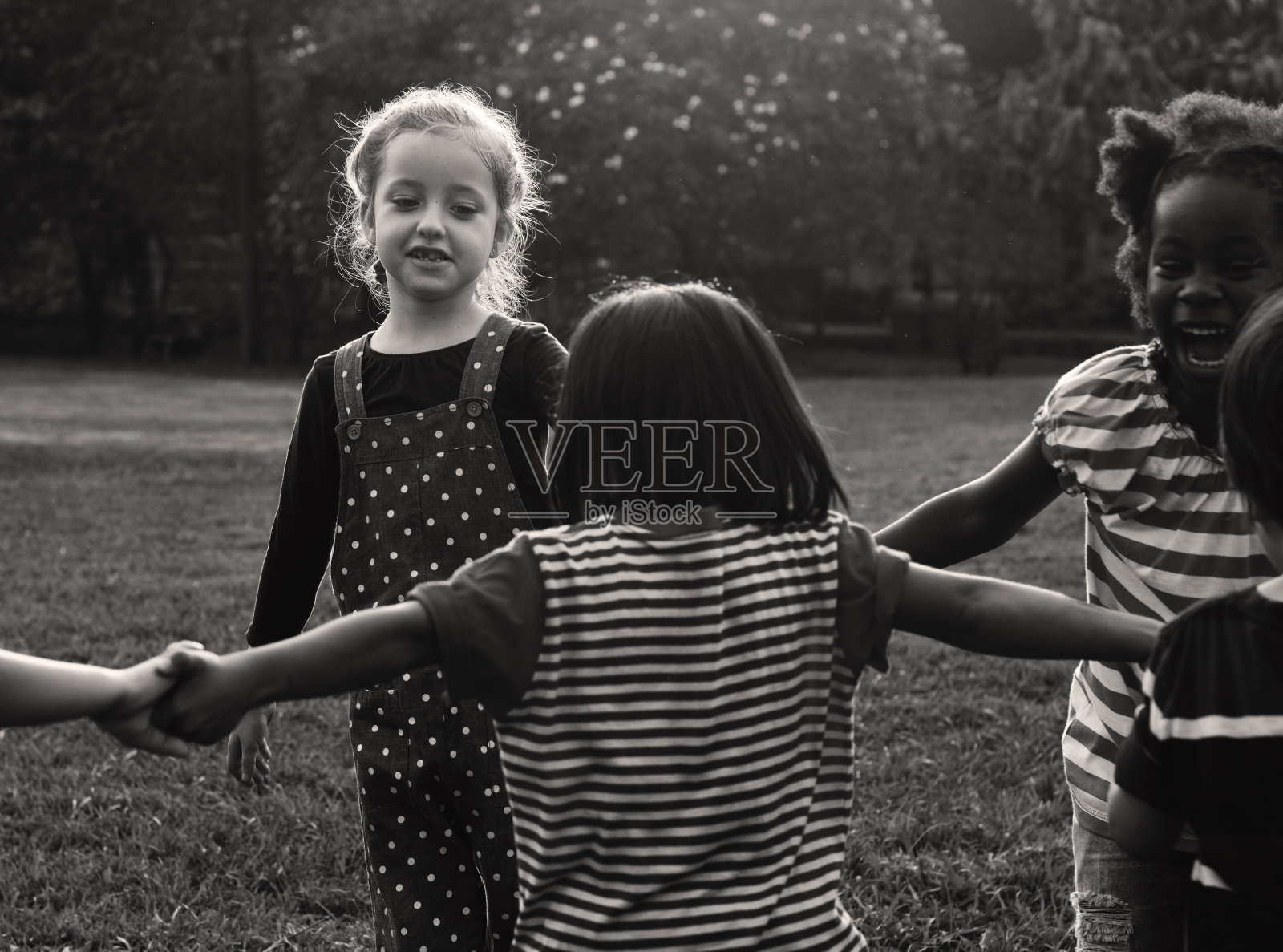 一群幼儿园小朋友手牵着手在公园里玩耍照片摄影图片