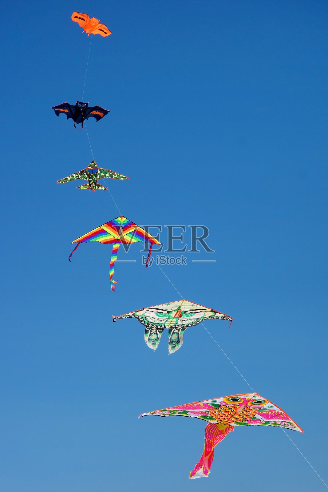 一组风筝在晴朗的蓝天上飞翔照片摄影图片
