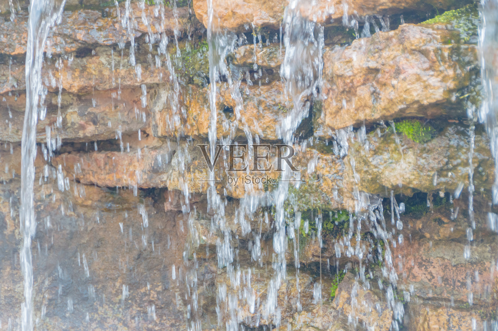 近看，褶皱的岩石潺潺流水照片摄影图片