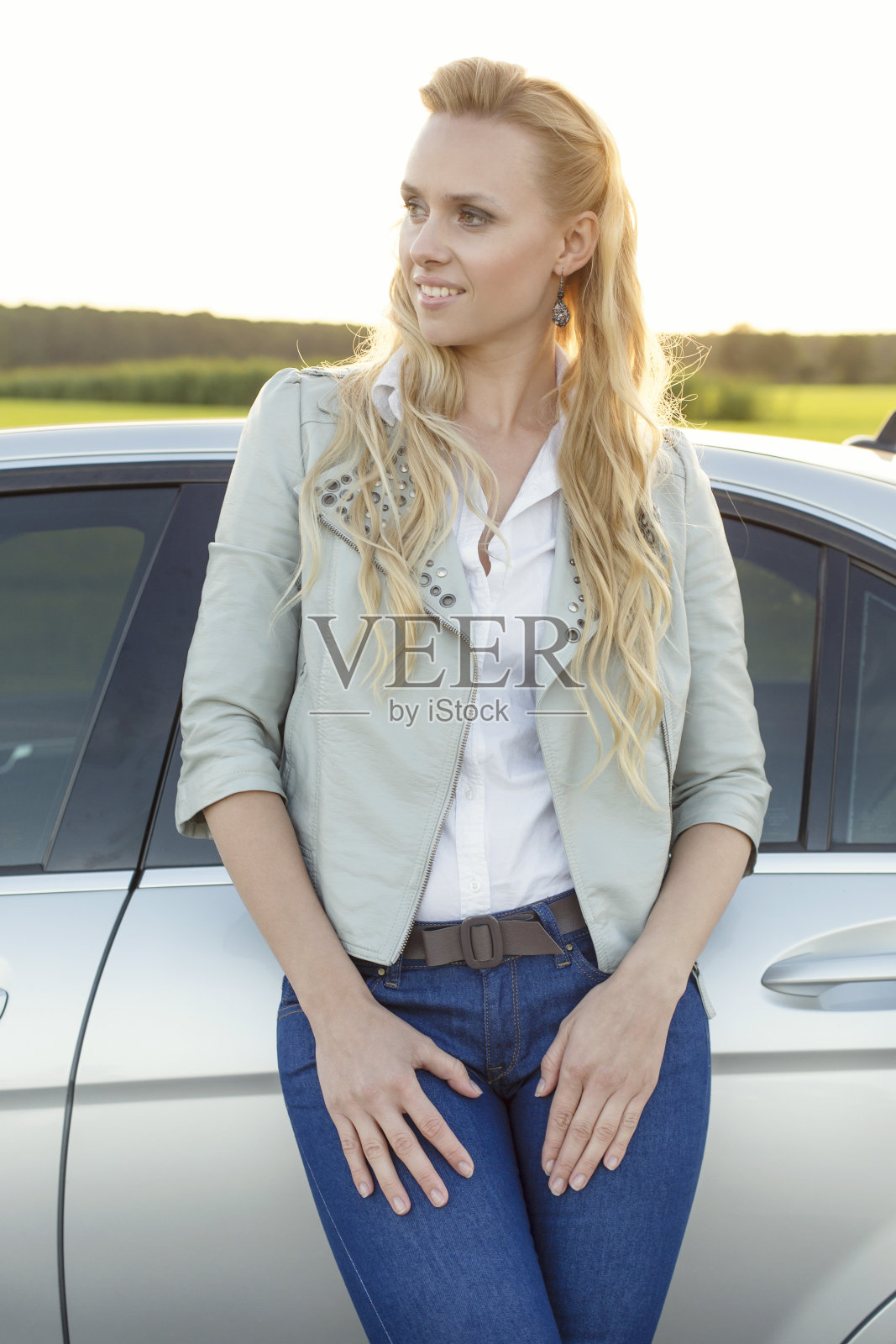 漂亮的年轻女子站在车旁看向别处照片摄影图片