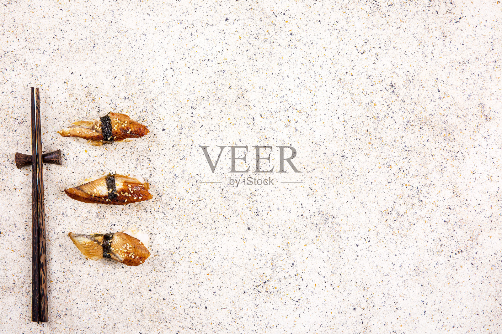 寿司配鳗鱼和寿司棒，背景是米色大理石照片摄影图片