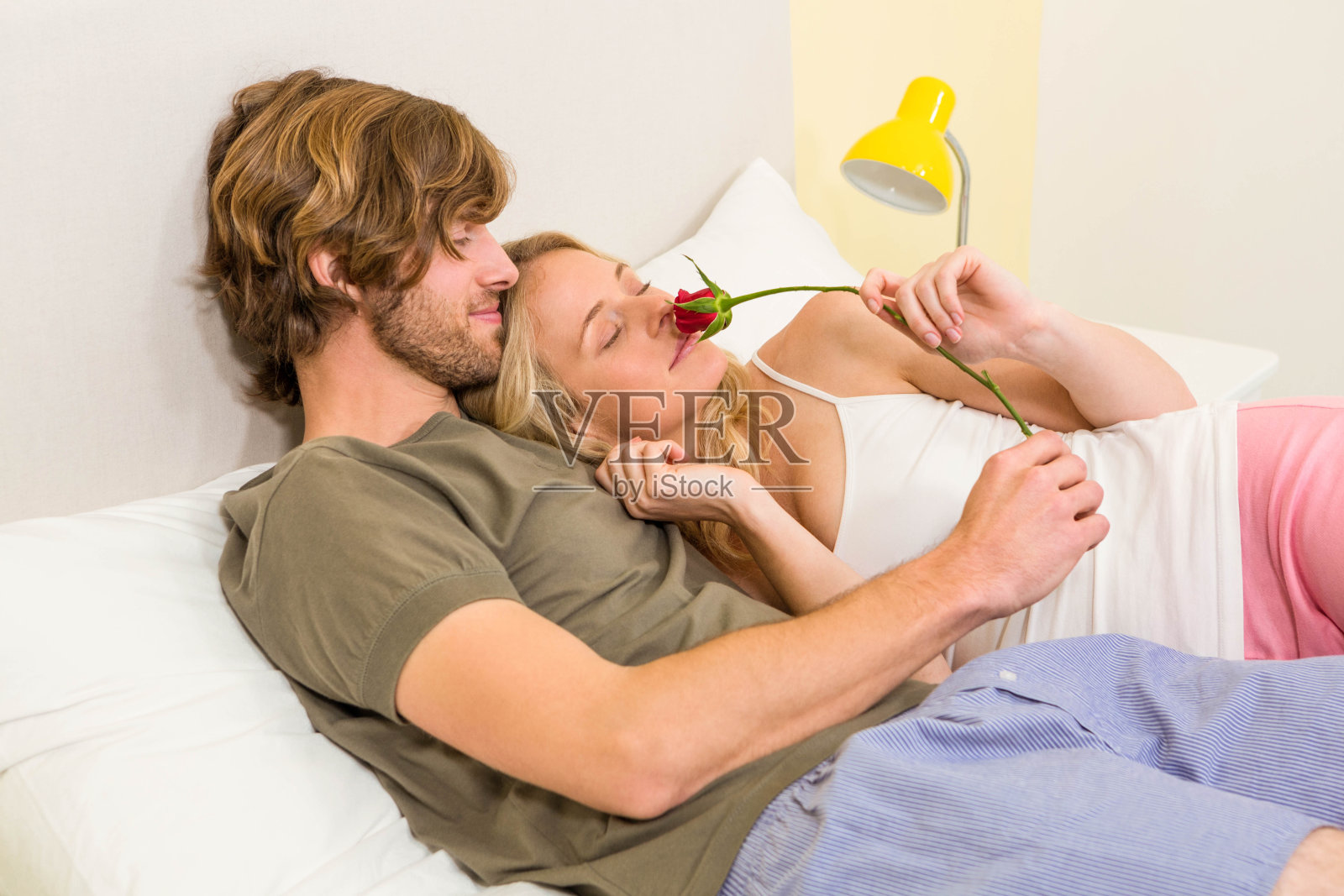 一对可爱的情侣抱着女友，闻着玫瑰照片摄影图片