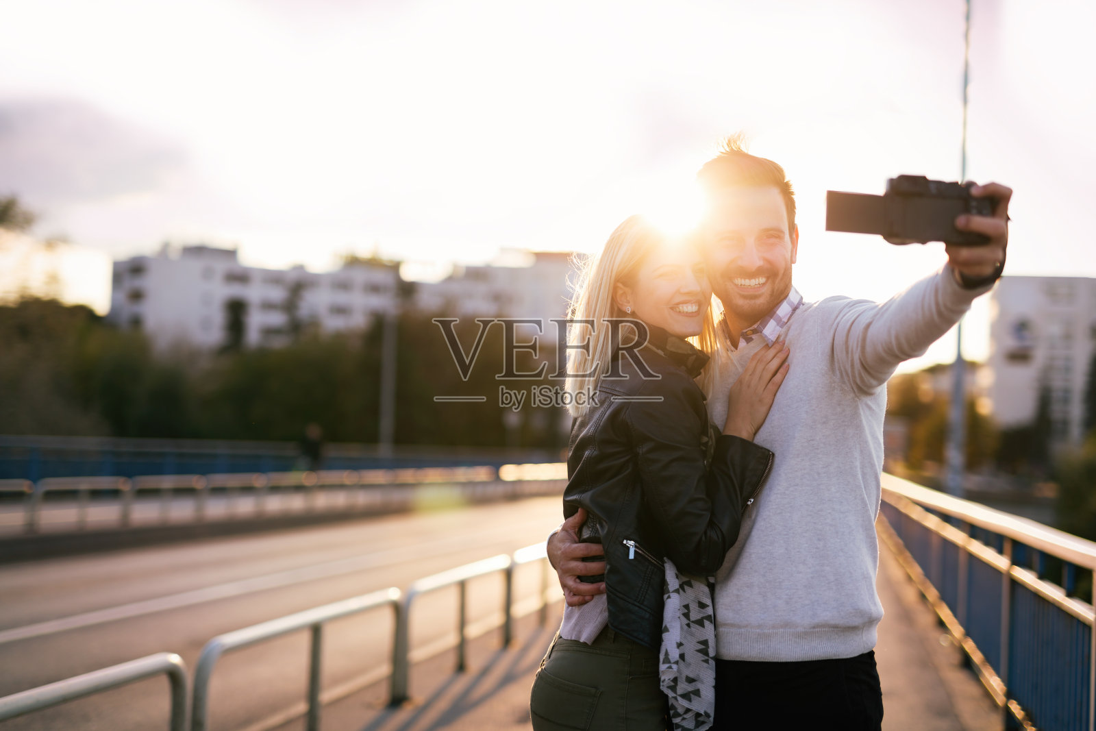 一对漂亮的年轻夫妇在桥上自拍照片摄影图片