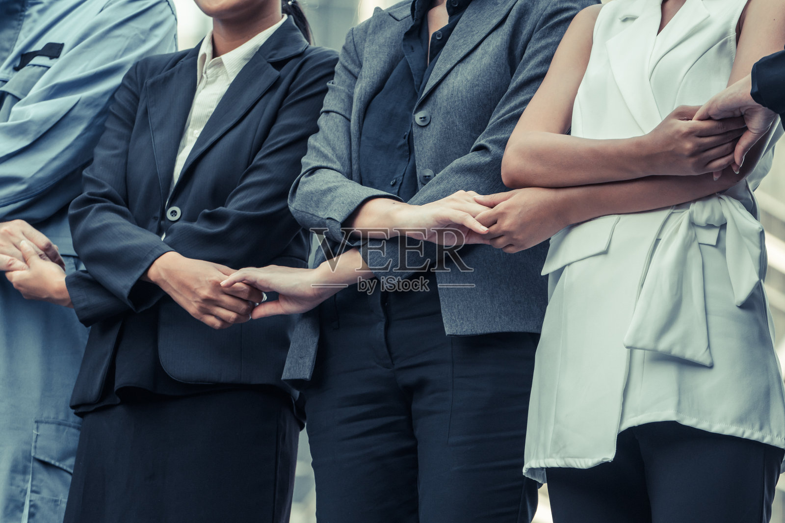商务人士手拉手展示团队精神。照片摄影图片