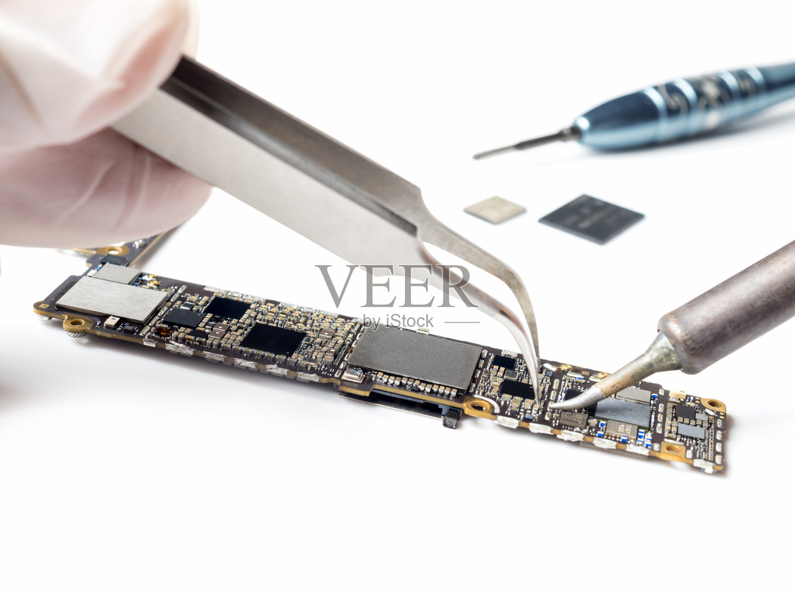 更换智能手机逻辑板芯片的技术员照片摄影图片