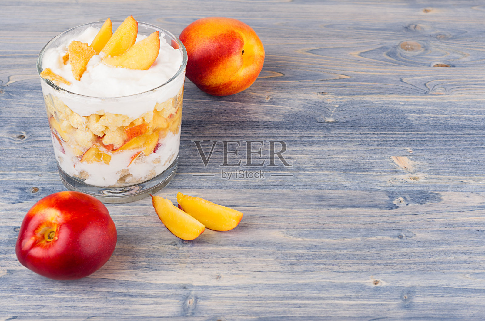 色彩斑斓的健康早餐:玉米片，熟桃片，蓝木板。带有拷贝空间的装饰边框。照片摄影图片