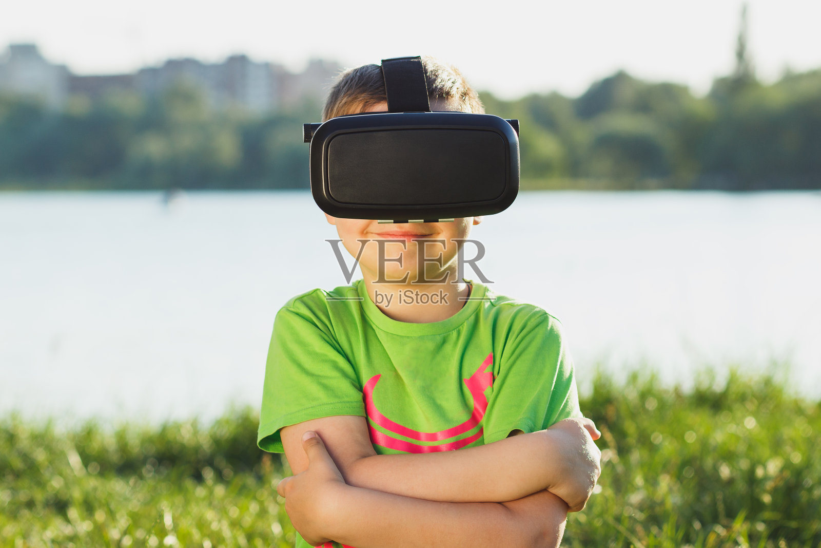 男孩戴着虚拟现实眼镜在户外玩游戏照片摄影图片