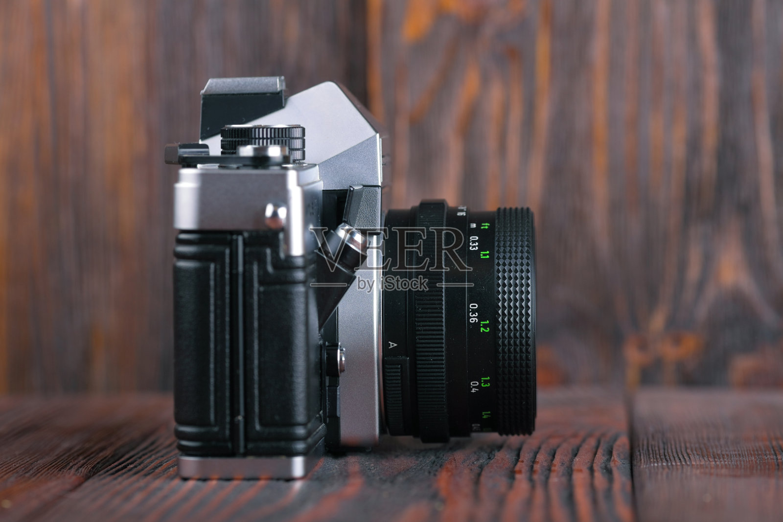 木质背景的老式35毫米单反相机。照片摄影图片