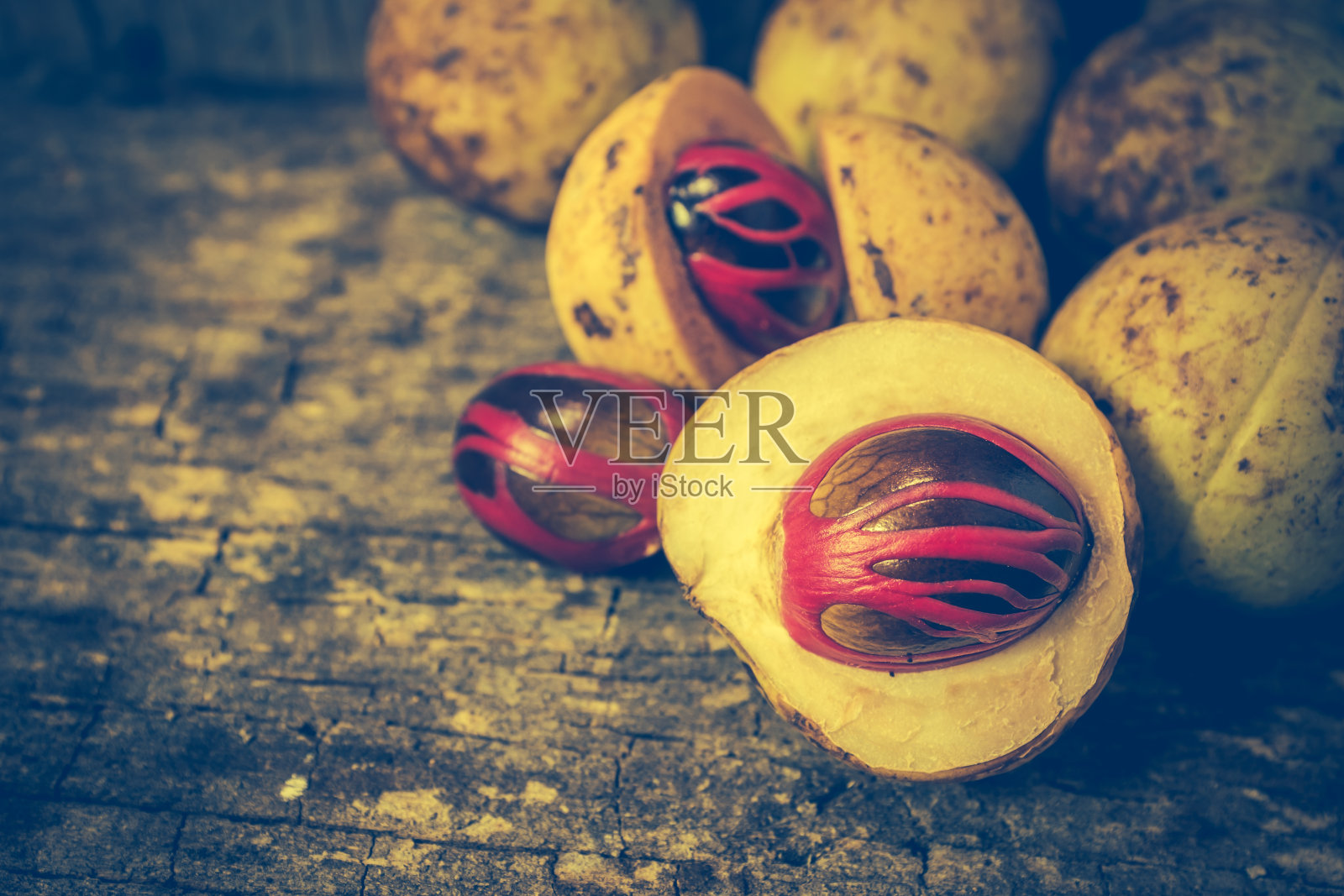 肉豆蔻具有胎盘状的肉豆蔻种子覆盖，在木质背景上芳香。照片摄影图片