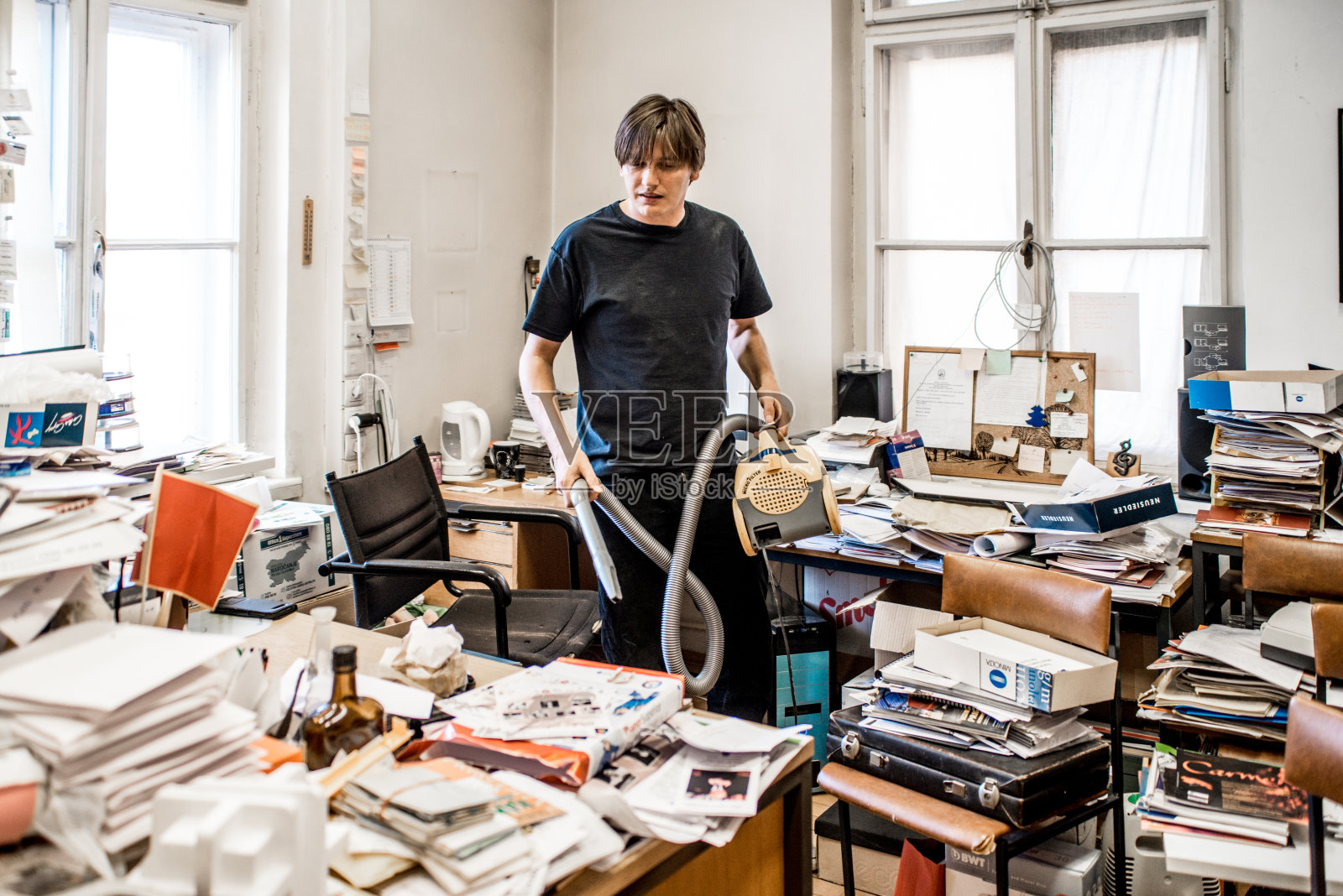 办公室工作人员试图清理凌乱的办公室照片摄影图片