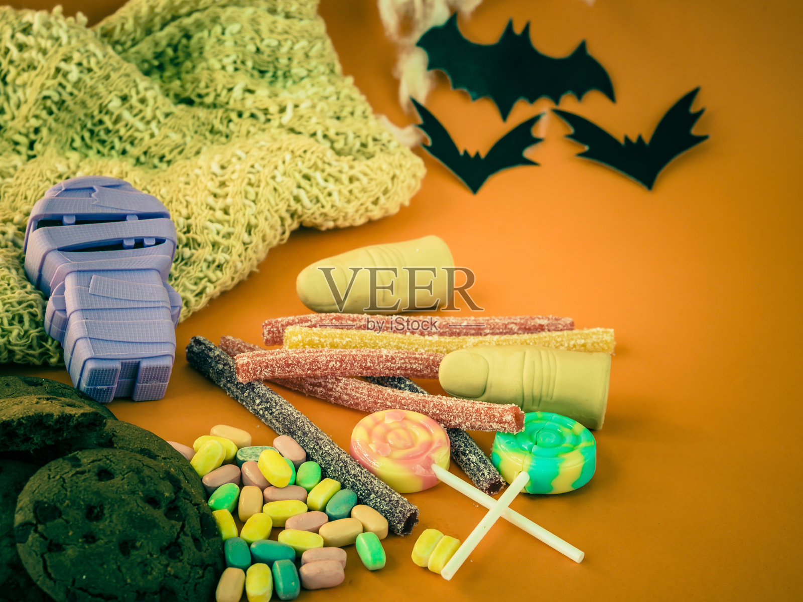 快乐万圣节装饰和糖果在橙色的背景。照片摄影图片