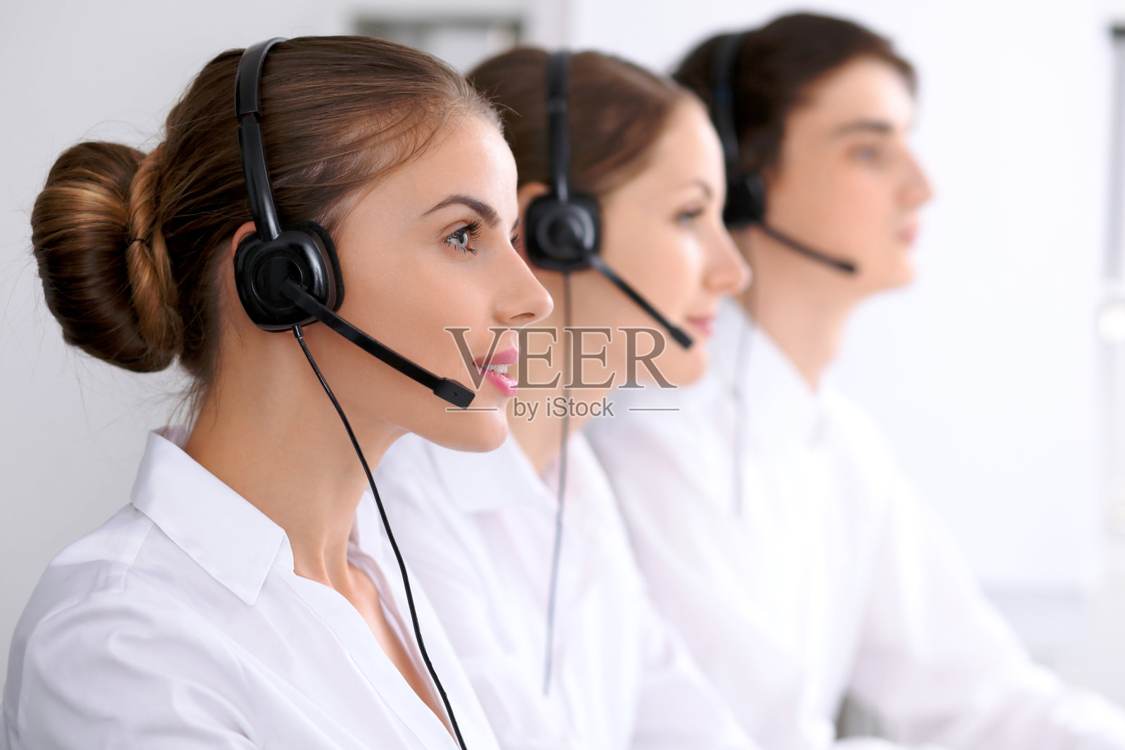 呼叫中心。关注戴耳机的美女照片摄影图片