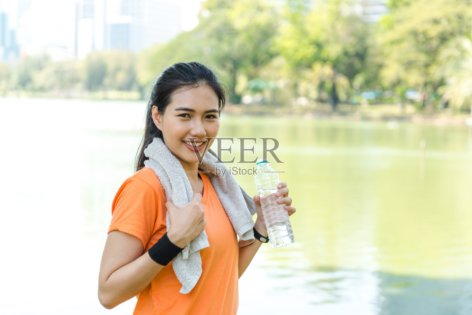 肖像有吸引力的自信微笑年轻的亚洲女子跑步拿着水瓶照片摄影图片