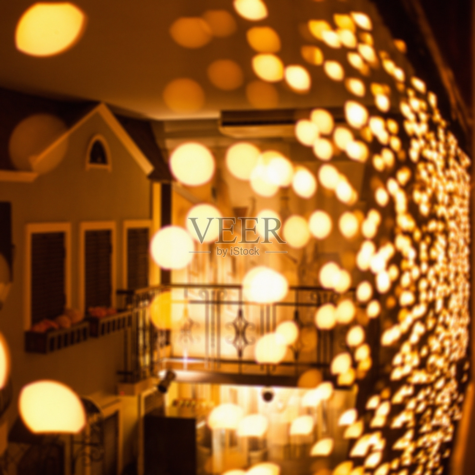 节日昏暗模糊的背景与散景灯，电动花环和房子照片摄影图片