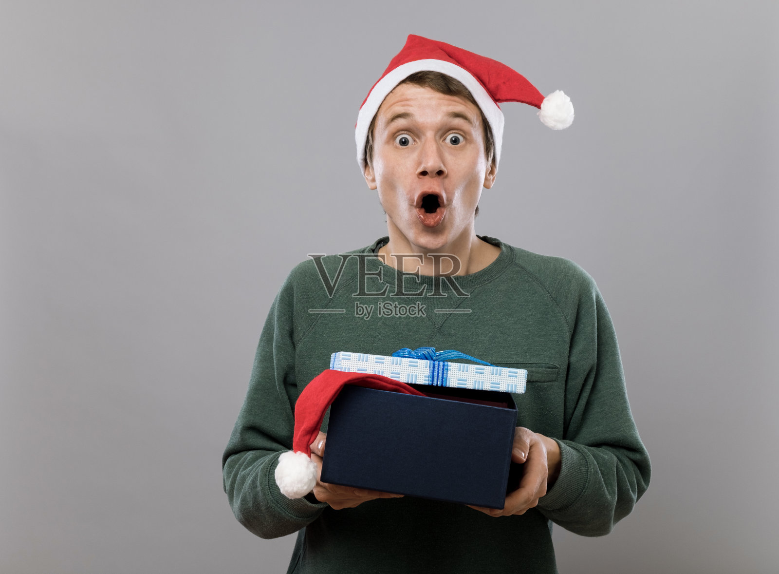 年轻有趣的人戴着圣诞帽和礼物照片摄影图片