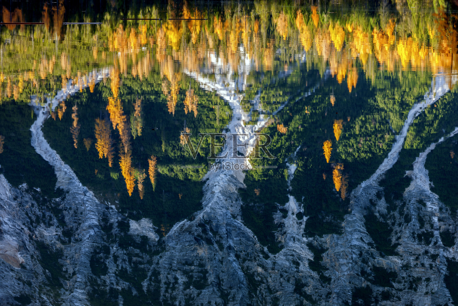 意大利阿尔卑斯山白云石的布雷斯湖，山上的岩石和秋天的森林倒映在水中照片摄影图片