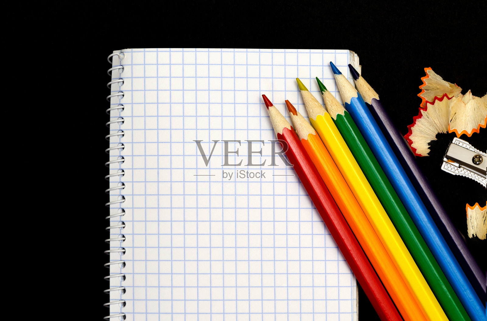 笔记本笔记和彩色铅笔在黑色的背景。照片摄影图片