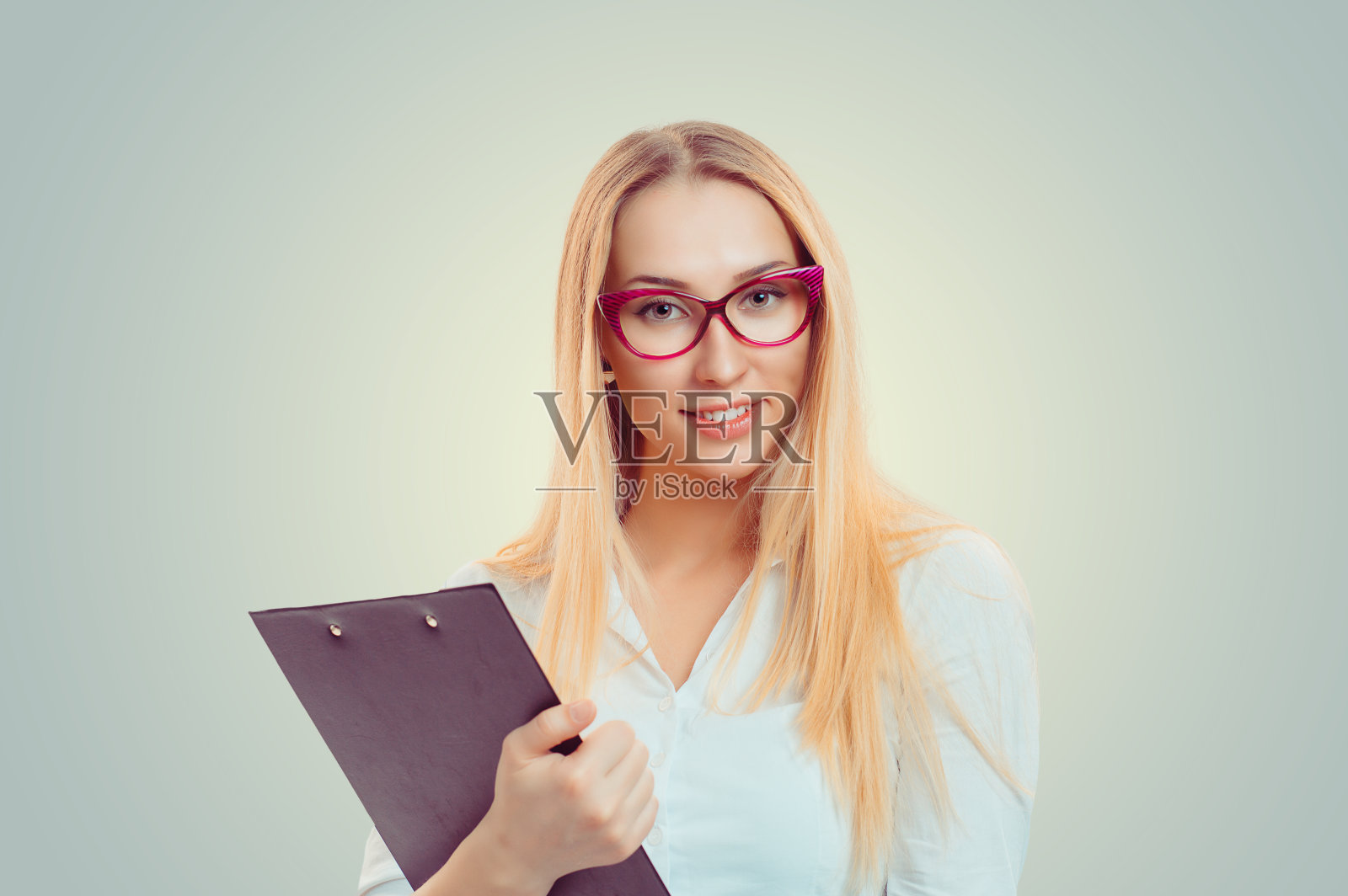 商业女人特写肖像大头照严肃自信的商业女人拿着剪贴板看着你孤立的绿色黄色墙壁背景白色衬衫人脸表情身体语言态度照片摄影图片