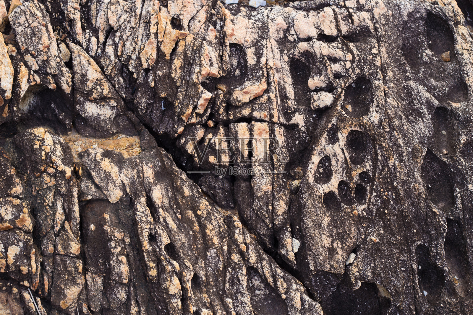 以海滩上古老火山岩的图案和纹理为背景。照片摄影图片