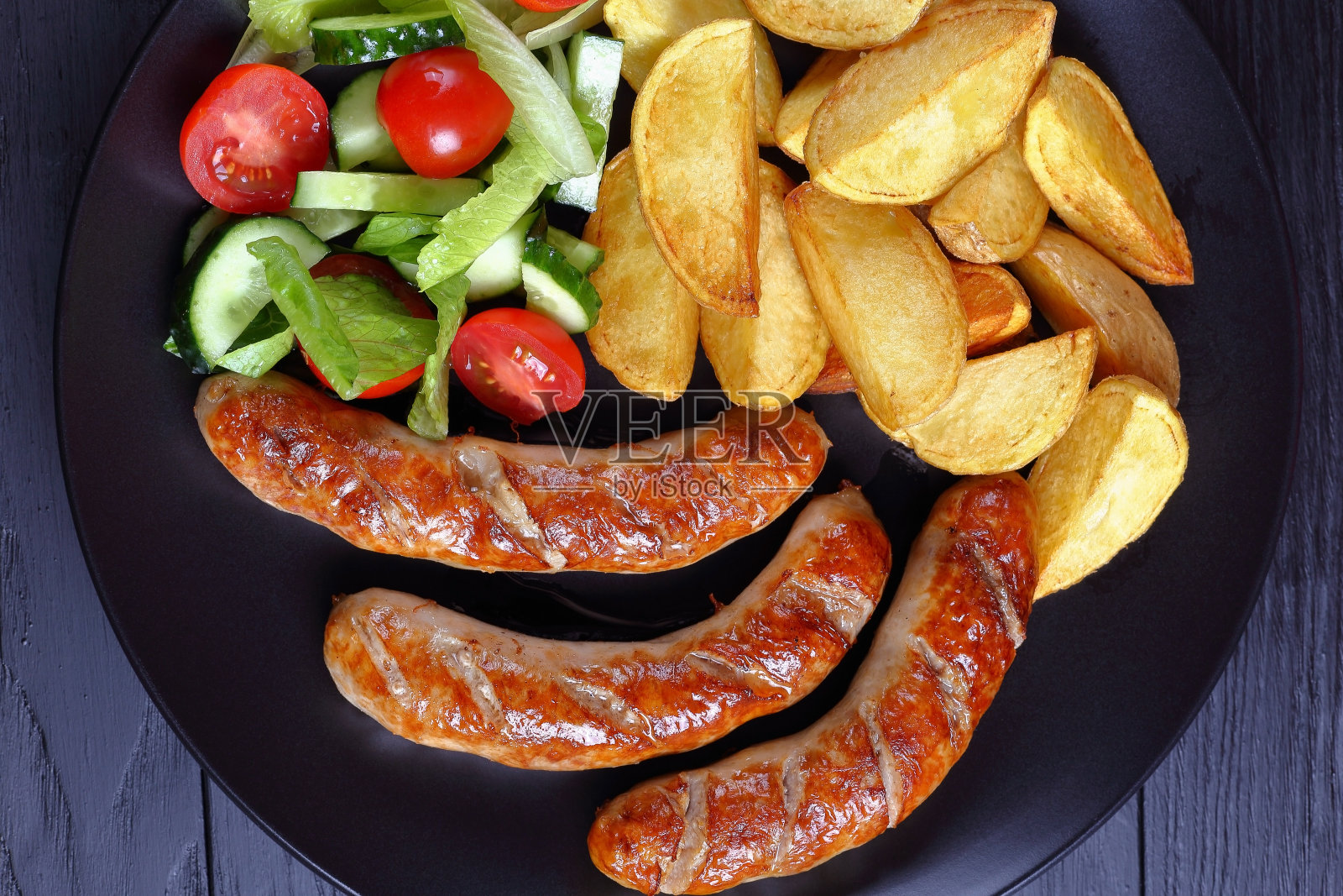 烤香肠，烤土豆，蔬菜沙拉照片摄影图片