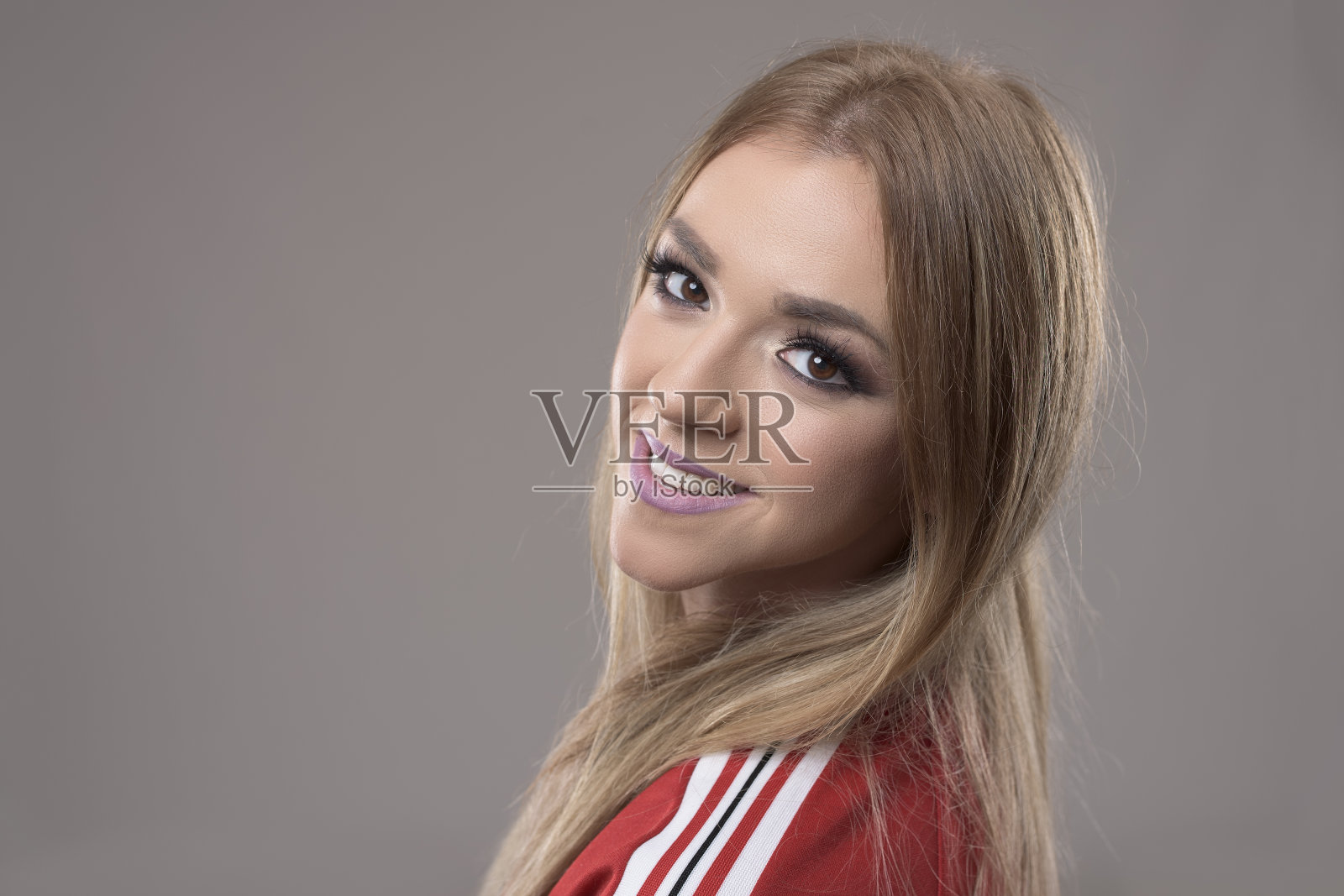 水平肖像的美丽的金发女人微笑看着相机的肩膀照片摄影图片