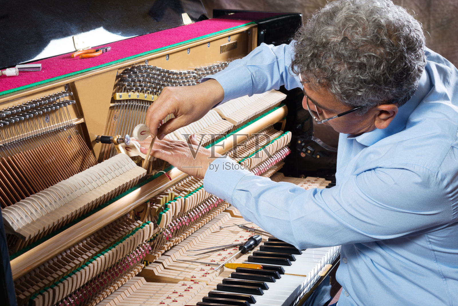 乐器技师正在修理钢琴照片摄影图片