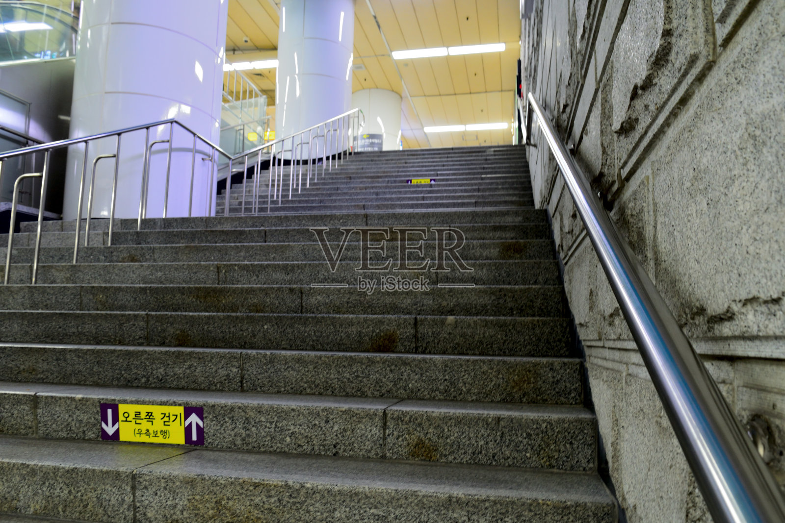 在上升的楼梯上，标牌用韩语写着“右转”照片摄影图片