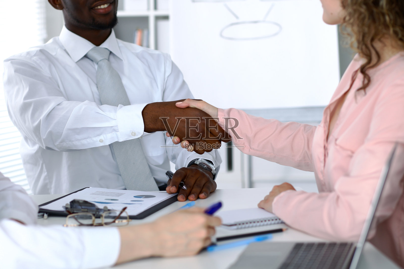 非裔美国商人在办公室与女性合伙人握手照片摄影图片