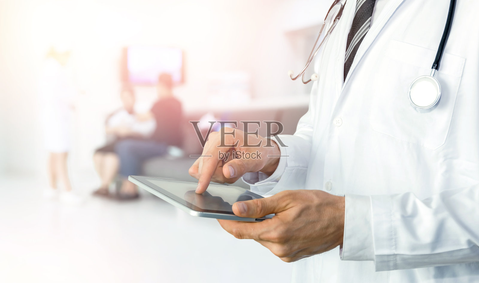 智能医疗物联网和医院自动化管理技术理念与无纸化。医生与听诊器使用片剂远程监测检查病人的状态。照片摄影图片