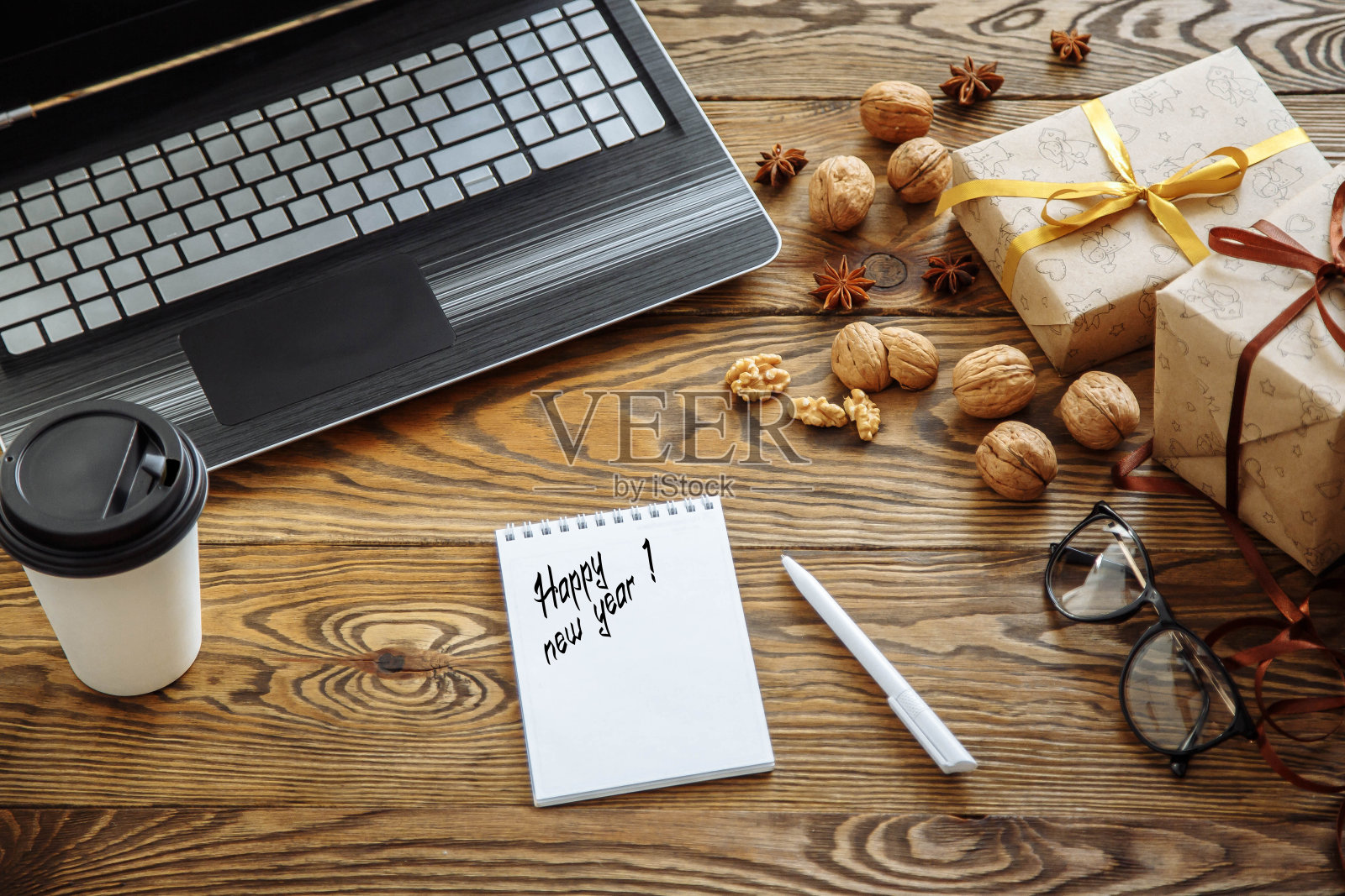 工作场所。礼品盒，笔记本电脑，咖啡和笔记本放在木桌上。照片摄影图片