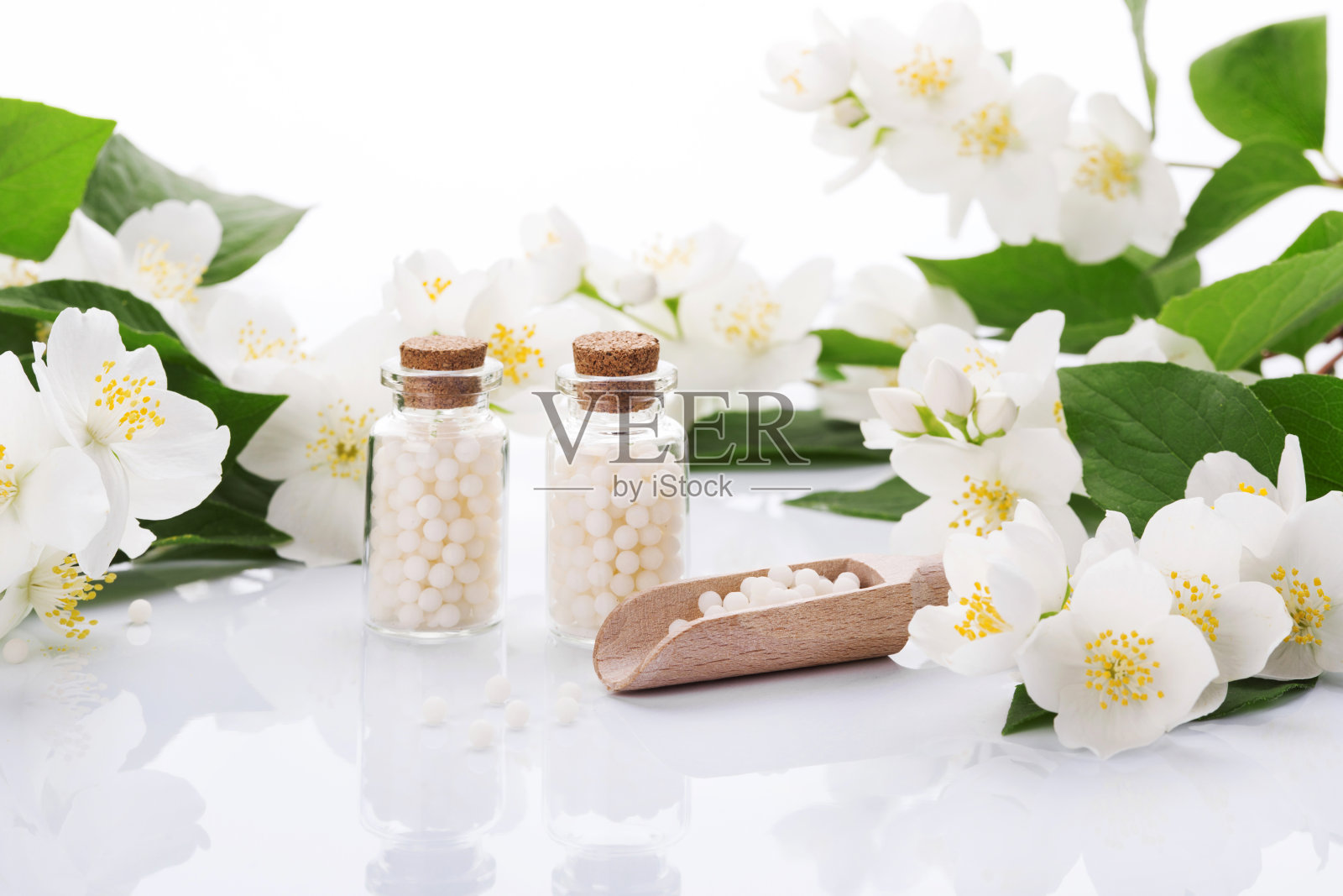 顺势疗法药丸与春天的花在白色的背景照片摄影图片