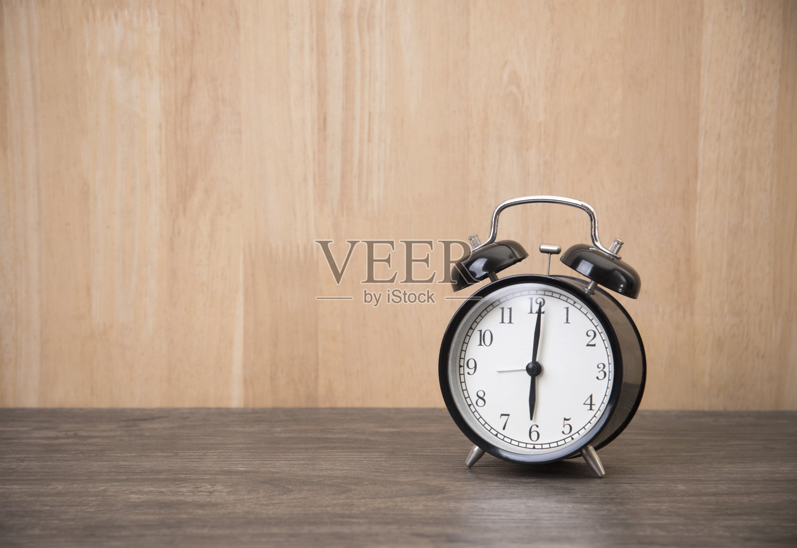 闹钟放在木桌上，复制空间用于产品展示蒙太奇。照片摄影图片