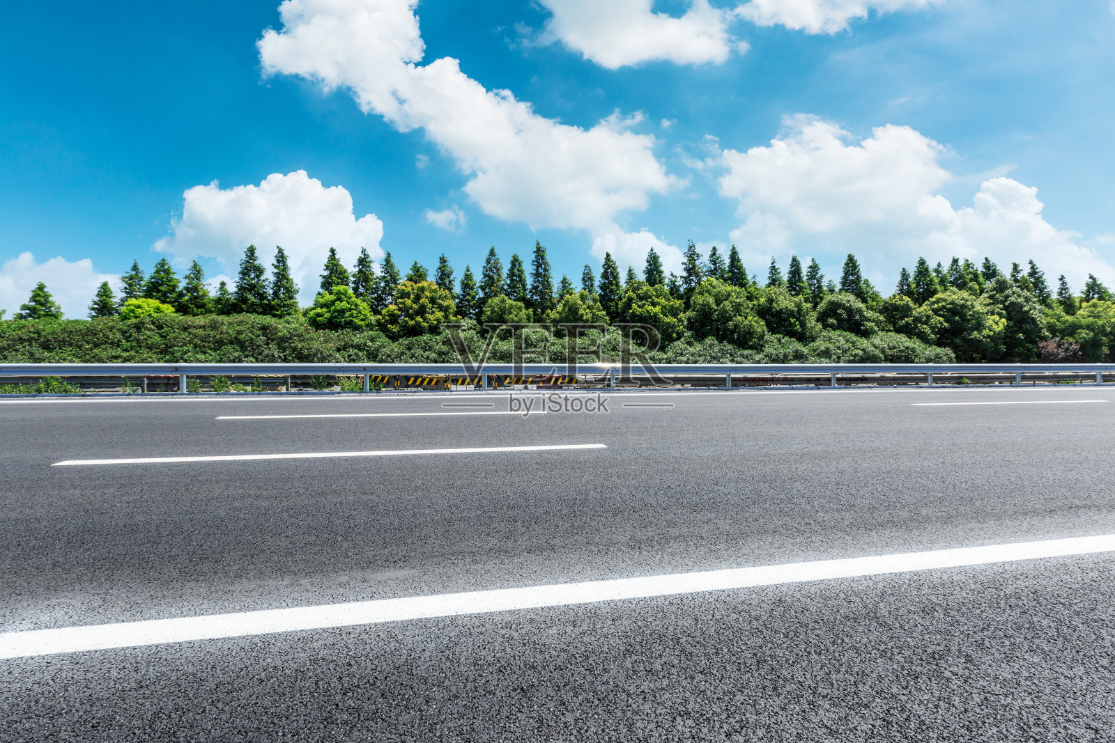碧海蓝天下的柏油路和绿林照片摄影图片