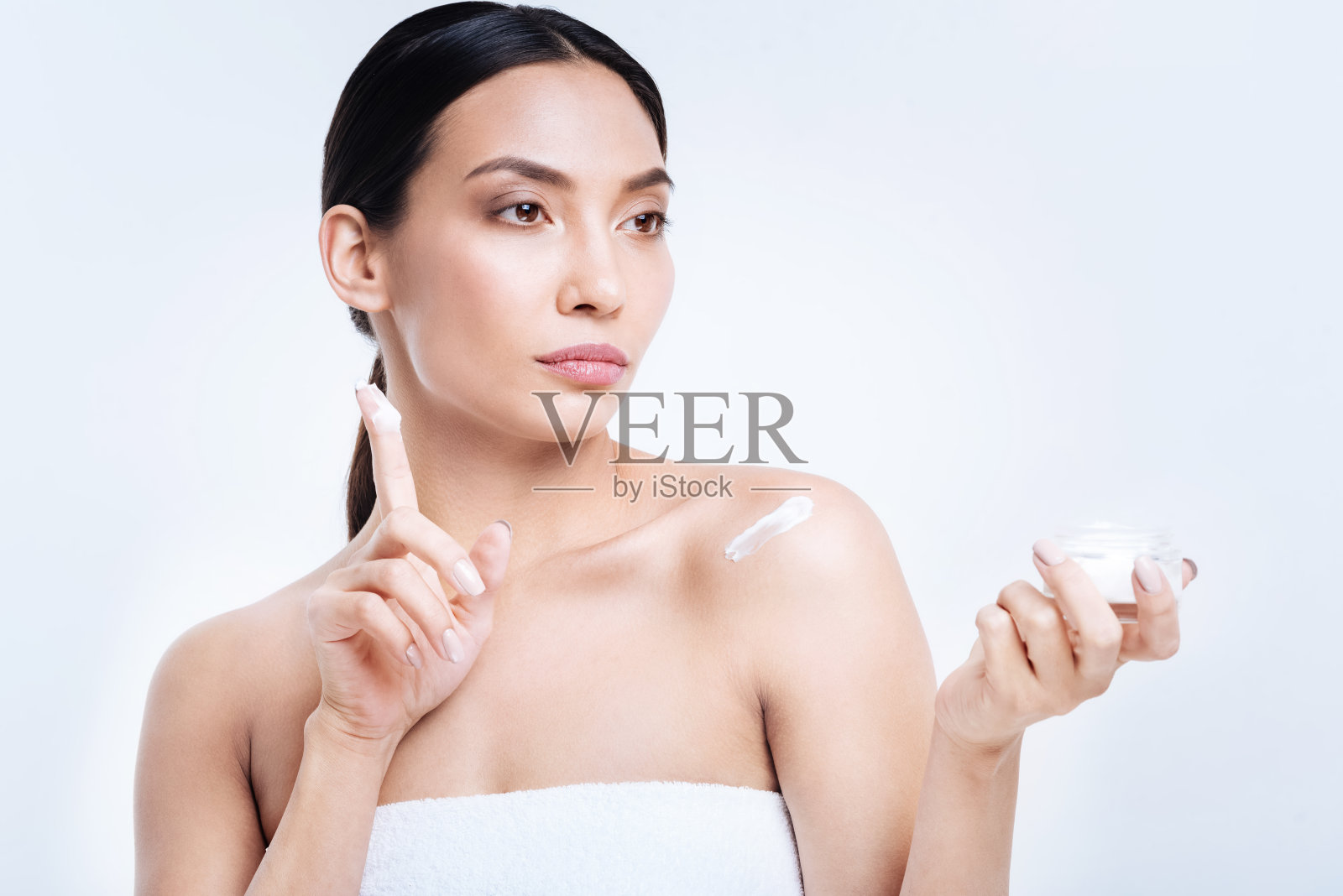 迷人的女人，手指上沾了奶油照片摄影图片