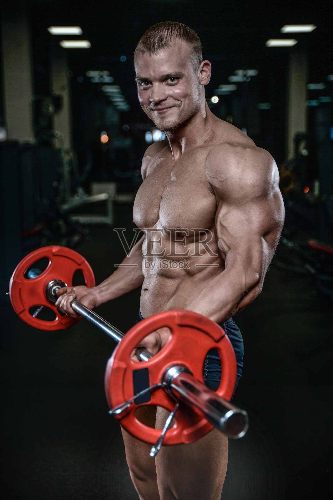 英俊的模特年轻男子在健身房训练手臂照片摄影图片