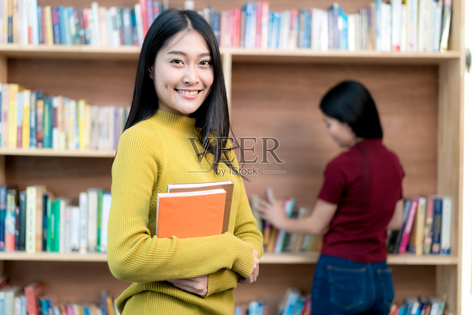 一群亚洲学生在大学图书馆一起学习。大学的学生。照片摄影图片