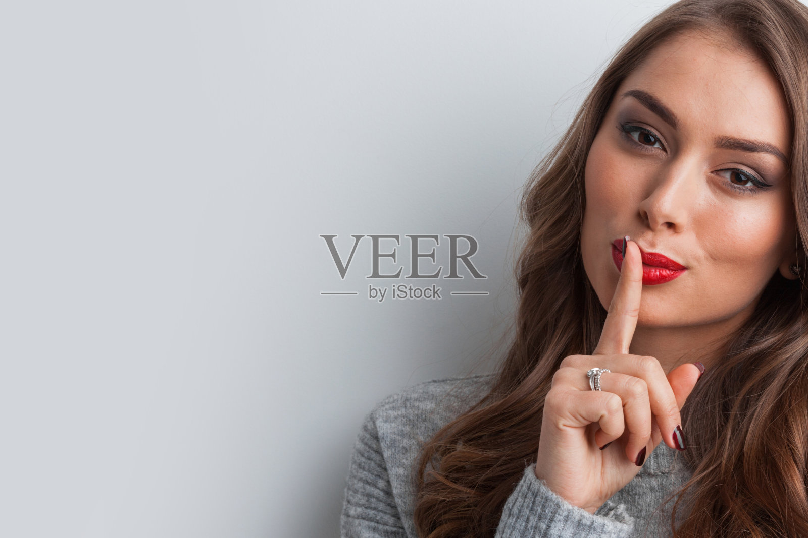 手指放在嘴唇上的女孩照片摄影图片