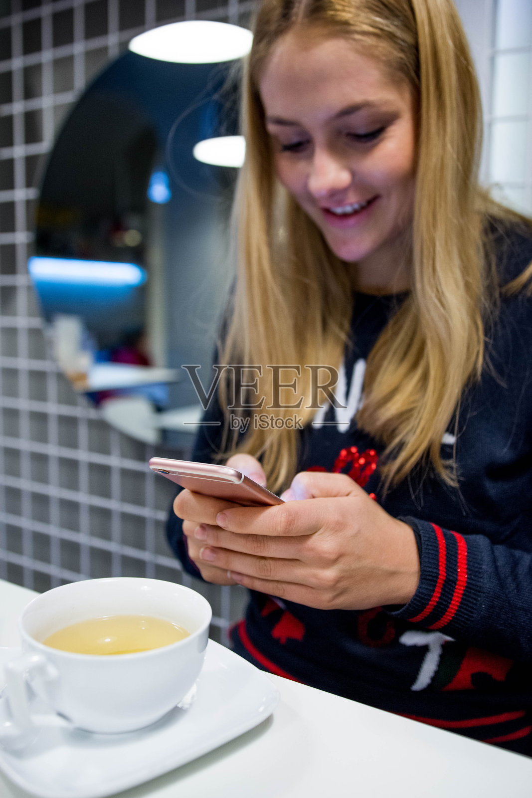 年轻女子用智能手机喝茶照片摄影图片